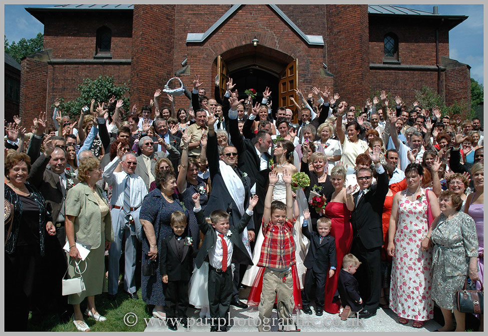 Wedding party stand on church steps cheering congratulations