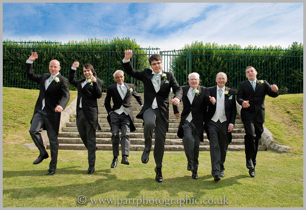 Groom and best men jump of a set of steps